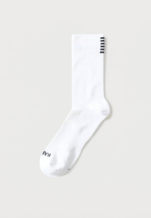 Egy fehér, egyrészes zokni fekete vízszintes csíkokkal a tetején és fekete szöveggel a lábujjrészén.