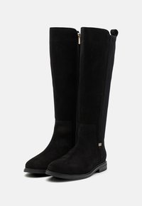 Black knee-high boots made of suede with a smooth texture. Features a side zipper and a contrasting elastic panel on the outer side.