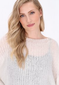 Leichter, gestrickter Pullover mit einem Farbverlauf von Rosa zu Grau. Er hat eine offene Maschenstruktur, einen weiten Ausschnitt und eine lockere Passform.