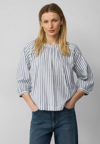 Blusa in cotone leggero a strisce di colore azzurro chiaro e bianco, con colletto tondo, dettagli arricciati e maniche a tre quarti.