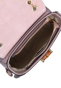 Crossbody handtas met een gladde faux leren buitenkant in lichtroze en gouden ritsen. Het interieur heeft een gestreepte stoffen voering en meerdere vakken.