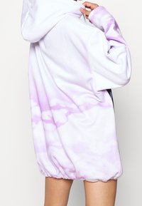Felpa con cappuccio in tessuto bianco con un motivo tie-dye lilla, dotata di orlo elasticizzato e maniche a vestibilità rilassata.