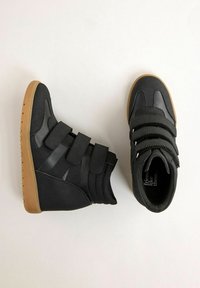 Tenisi negri cu glezna înaltă, cu t�ălpi din cauciuc, trei chingi cu velcro și guler căptușit pentru glezne, afișați din perspective laterale și de sus pe un fundal deschis.
