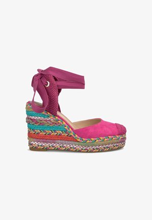 Fuchsia suède wedge sandaal met een multikleurige gevlochten touwzool en enkelband. Kenmerken zijn een getextureerde bovenkant en verschillende levendige accenten.