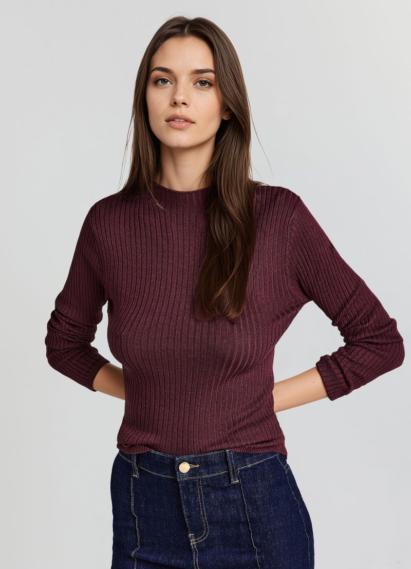 Burgunderfarbener, gerippter Strickpullover mit langen Ärmeln und Rundhalsausschnitt, kombiniert mit einem hoch geschnittenen, dunklen Denimrock mit einem vorderen Knopfdetail.