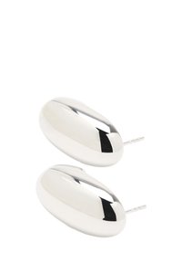 Srebrne owalne kolczyki o gładkiej, odbijającej świetle powierzchni i z tylnym zapięciem. Posiadają zaokrąglone krawędzie i minimalistyczny design.