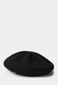 Melns adīts berets ar teksturētu rakstu, apaļu formu un mazu zelta akcentu sānos. Mīksts, elastīgs materiāls.