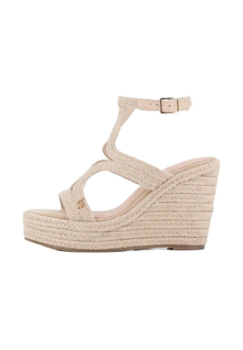 Sandalia de cuña beige con correas trenzadas texturizadas, hebilla en el tobillo y suela de plataforma. Presenta un diseño de cuerda apilada para mayor altura.