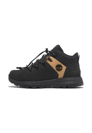 Chaussures de randonnée noires avec un accent beige, dotées d'une semelle robuste, d'un tissu durable, d'un système de laçage, et d'un logo sur le panneau latéral.