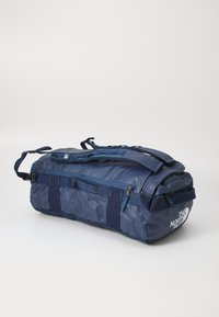 Tengerészeti tornazsák tartós nylon anyagból, dupla fogantyúval és állítható vállpánttal. Cipzárokkal és logó részletekkel rendelkezik.