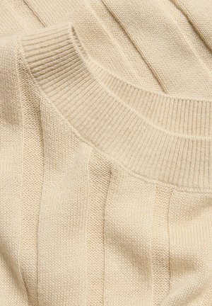 Vaaleanbeige ribattu neulepaita, jossa on pyöreä kaula-aukko, pehmeä rakenne ja tasainen kuviointi koko paidan alueella.