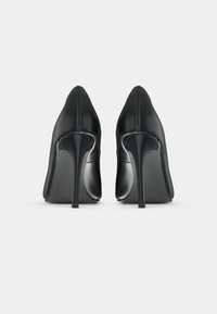 Čierne kožené vysoké topánky na podpätku s špicatou špičkou a elegantným dizajnom. Majú tenký stiletto podpätok a hladký, lesklý povrch.