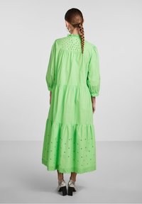 Abito in cotone verde a strati con dettagli in pizzo, maniche lunghe e orlo a scalloped. Caratterizzato da un collo alto e una vestibilità comoda.