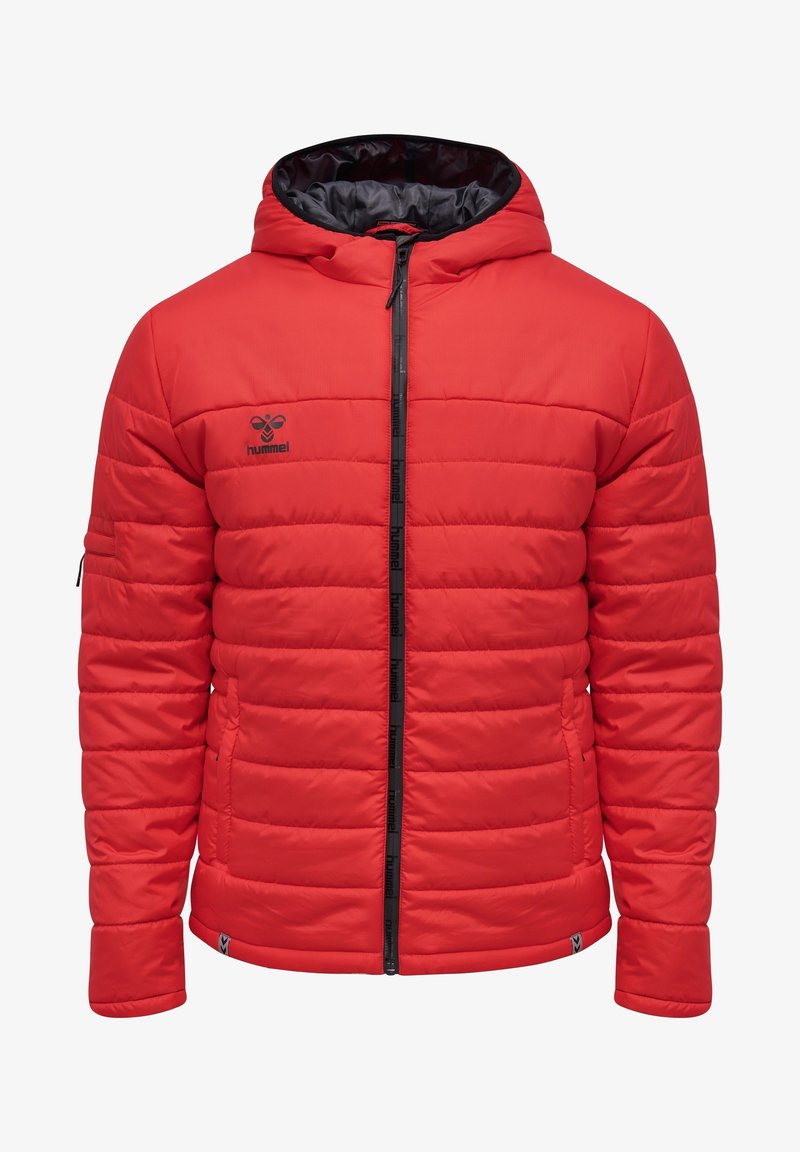 Veste rouge matelassée à capuche avec fermeture éclair noire, logo Hummel sur le côté gauche de la poitrine et détails de poche sur le bras.