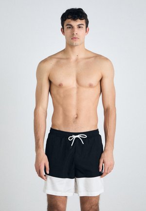 Schwarz-weiße Badeshorts mit einem elastischen Bund, Kordelzug und einem kontrastierenden weißen horizontalen Streifen am unteren Ende.