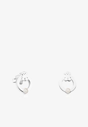 Pendientes de plata con forma de un motivo circular de oso, que presentan una perla blanca en el centro. Textura suave con acabado pulido.