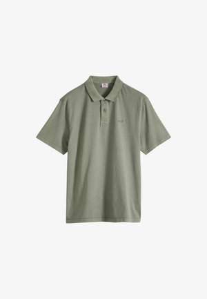 Olivinvihreä lyhythihainen poolopaita puuvillasta. Siinä on klassinen kaulus, kolmen napin nappilista ja hillitty logo vasemmalla rinnalla.