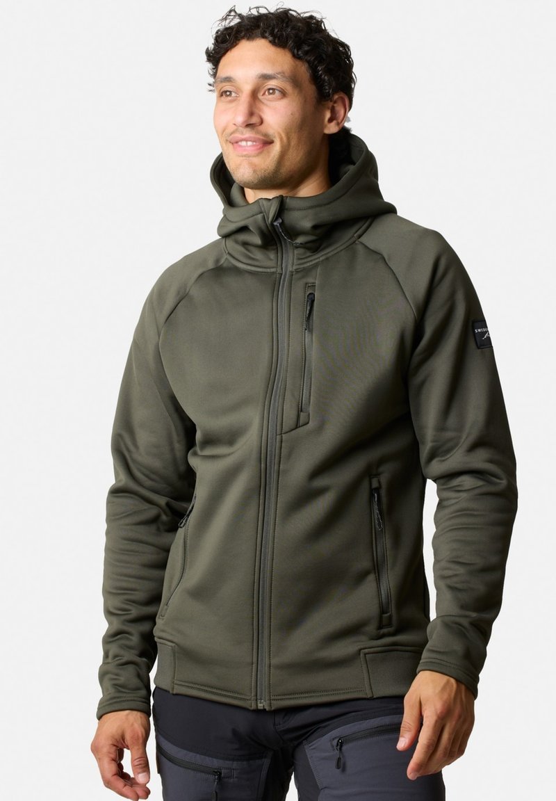 Felpa verde oliva con zip e colletto alto, due tasche laterali e una tasca sul petto; realizzata in un tessuto liscio e stretch, con un design aderente.