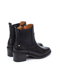 Stivali ankle in pelle nera con punta rotonda, pannelli laterali elastici a coste e tacco basso a blocco. Presentano un accento in tonalità oro.