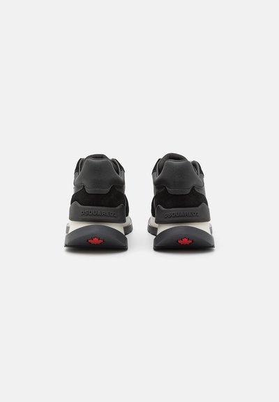 Sorte athletic sko med suede- og mesh-materialer, rund silhuet, solid grå sål og rødt ahornblad-detalje på hælen.