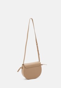 Hnědá crossbody taška vyrobená ze strukturovaného materiálu; má zaoblený tvar, plochý víko, nastavitelný popruh a detail uzlu na boku.