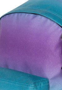 Plecak z gradientowym wzorem przechodzącym od turkusu do fioletu, wykonany z teksturowanej tkaniny z delikatnym połyskiem oraz zewnętrzną kieszenią.