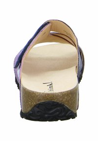 Rückansicht einer Sandale mit schwarzem gemustertem Obermaterial, einem Korkfußbett und einer strukturierten schwarzen Gummisohle. Die Riemen sind breit und unterstützend.