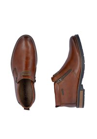 Bottines en cuir marron avec fermetures éclair latérales, semelles en caoutchouc noir et empiècements élastiques, vues de dessus et de côté sur fond blanc.