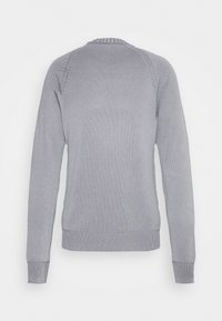Pull tricoté gris clair à manches longues avec motif texturé, poignets, ourlet et col côtelés, vu de dos sur un fond uni.