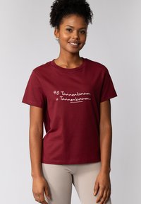 Burgunderfarbendes Baumwoll-T-Shirt mit weißem Text „O Tannenbaum, O Tannenbaum...“, kurzen Ärmeln und rundem Ausschnitt.