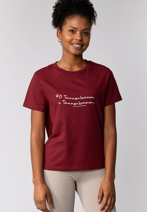 Bordeaux katoenen t-shirt met witte tekst "O Tannenbaum, O Tannenbaum..." met korte mouwen en een ronde hals.