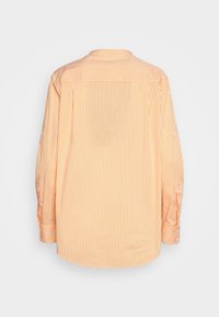 Long-sleeve orange and white vertical striped shirt shown from the back on a plain white background.