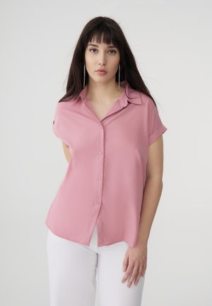 Blusa corta rosa a maniche corte con chiusura a bottoni, colletto rigido e un tessuto liscio e leggero; presenta una vestibilità rilassata e spacchi laterali all'orlo.