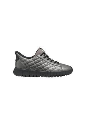 Lage grijze sneaker met doorgestikte details, zwarte veters en een dikke zwarte gesegmenteerde zool, zijaanzicht op een witte achtergrond.