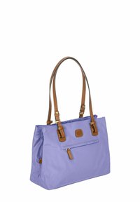 Borsa tote in nylon viola con manici in pelle marrone, dotata di una tasca frontale con zip e una patch con il logo. Texture liscia con forma morbida e strutturata.