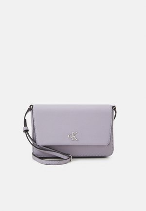 Jasnofioletowa torba Calvin Klein na ramię z klapką i regulowanym paskiem, z srebrnym logo "cK" z przodu.