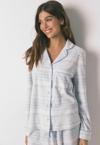 Completo pigiama azzurro chiaro in morbido tessuto, con un motivo geometrico, camicia con bottoni e maniche lunghe, rifinito con bordi in contrasto e tasca.