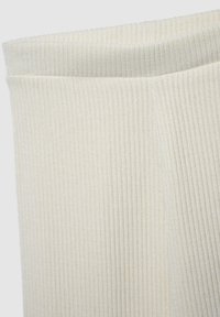 Tessuto a coste color bianco sporco con una superficie testurizzata, caratterizzato da un ampio polsino morbido e righe verticali. Nessun motivo o dettaglio particolare.