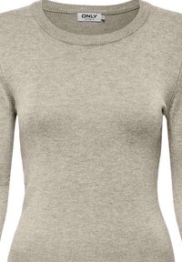 Pull gris clair à manches longues en tissu tricoté doux, avec un col rond et un ourlet côtelé, présentant une texture simple et lisse.