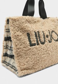 Borsa a spalla in pelliccia sintetica beige con manici neri a nastro, dotata di logo ricamato "LIU•JO" e motivo a scacchi all'interno.