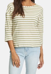 Randig långärmad skjorta i ljusgrön och off-white, mjukt bomullsmaterial, med en avslappnad passform och båthals-design.