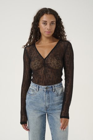 Black lace long-sleeve top with a V-neck and sheer design, paired with high-waisted blue denim jeans featuring a classic five-pocket style.