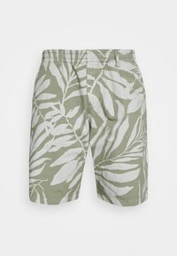 Lysegrønne shorts lavet af stof med hvide bladmønstre. Har klassisk pasform og elastisk talje med frontlommer.