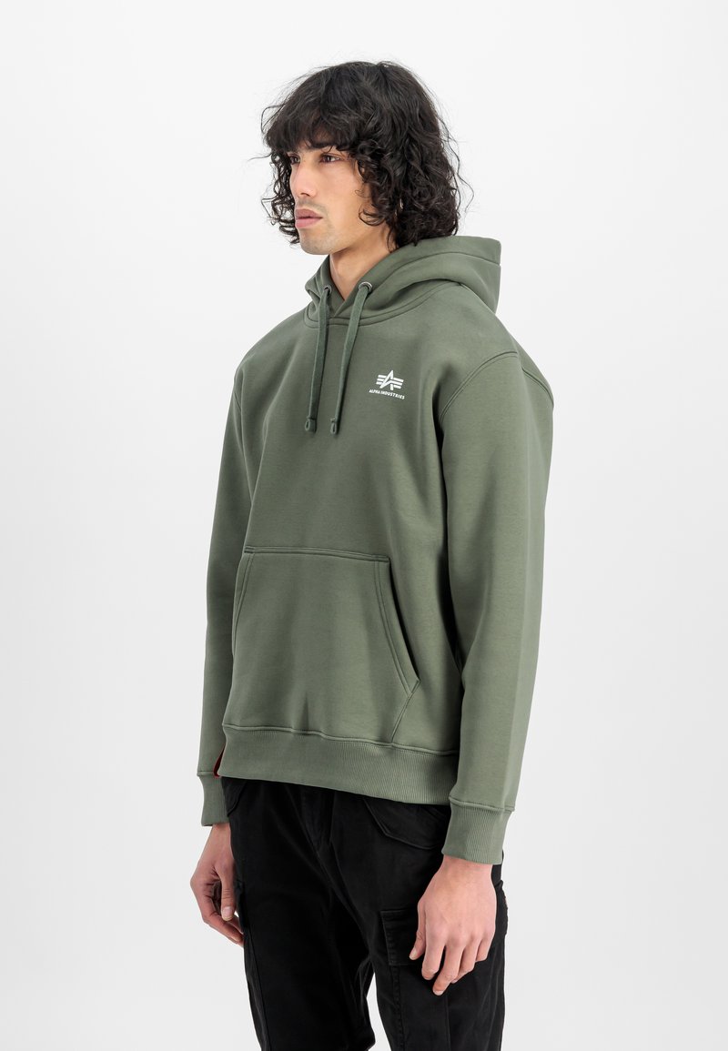 Olivgrüner Hoodie aus weichem Stoff, mit einer Kängurutasche, Zugbandkapuze und kleinem weißen Logo auf der Brust. Klassische Passform mit gerippten Bündchen.
