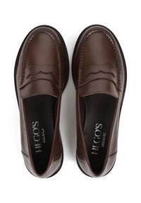 Brązowe skórzane mokasyny z wypukłym wzorem i gładką fakturą, z zapięciem na wsuwanie i minimalistycznym brandingiem wewnątrz.