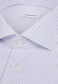 Wit overhemd met lichtblauwe verticale strepen, een geknoopte kraag en het merklabel "seidensticker" aan de binnenkant van de kraag.