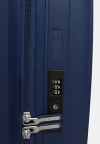 Valigia rigida della marina con superficie testurizzata, doppie cerniere argento, lucchetto a combinazione integrato e slot per etichetta identificativa.