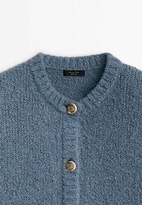 Cardigan en tricot bleu avec une finition texturée, doté d'un col côtelé et de trois boutons dorés à l'avant.