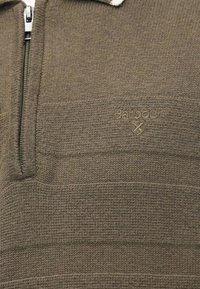 Sweater castanho tricotado com fecho éclair parcial e logo Barbour bordado de forma subtil no peito.