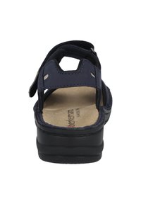 Dunkelblaue Sandale mit schwarzer Sohle, verstellbaren Riemen und gepolstertem Fußbett. Mit Nähdetails und ausgeschnittenen Seiten für Atmungsaktivität.